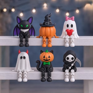 May include: A set of six small Halloween-themed figurines with dangling legs. The figures include a black bat, a pumpkin wearing a witch hat, a white ghost with a pink bow holding a red heart, a white ghost with red horns, a black cat with a pumpkin head, and a grim reaper.