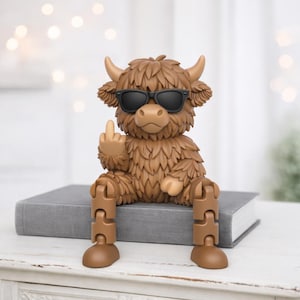 May include: A brown figurine of a Highland cow wearing black sunglasses and giving the middle finger. The cow is sitting on a gray book. The figurine has articulated legs and is a humorous decorative item.
