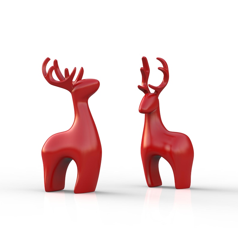 May include: Two glossy red reindeer figurines. The reindeer have stylized bodies and antlers, standing on a white surface. The figurines are a festive decoration, perfect for the holiday season.