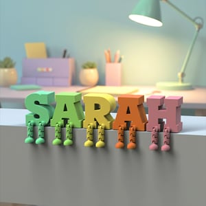 May include: A colorful, 3D-rendered name, "SARAH", with each letter in a different color: green, yellow, orange, and pink. Each letter has attached legs. The letters are on a white surface.