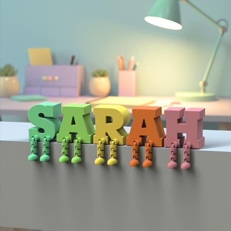 May include: A colorful, 3D-rendered name, "SARAH", with each letter in a different color: green, yellow, orange, and pink. Each letter has attached legs. The letters are on a white surface.
