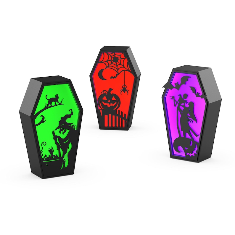 May include: Three black coffin-shaped Halloween decorations with illuminated interiors. One glows green with a witch silhouette, another red with a pumpkin, and the third purple with a couple silhouette.