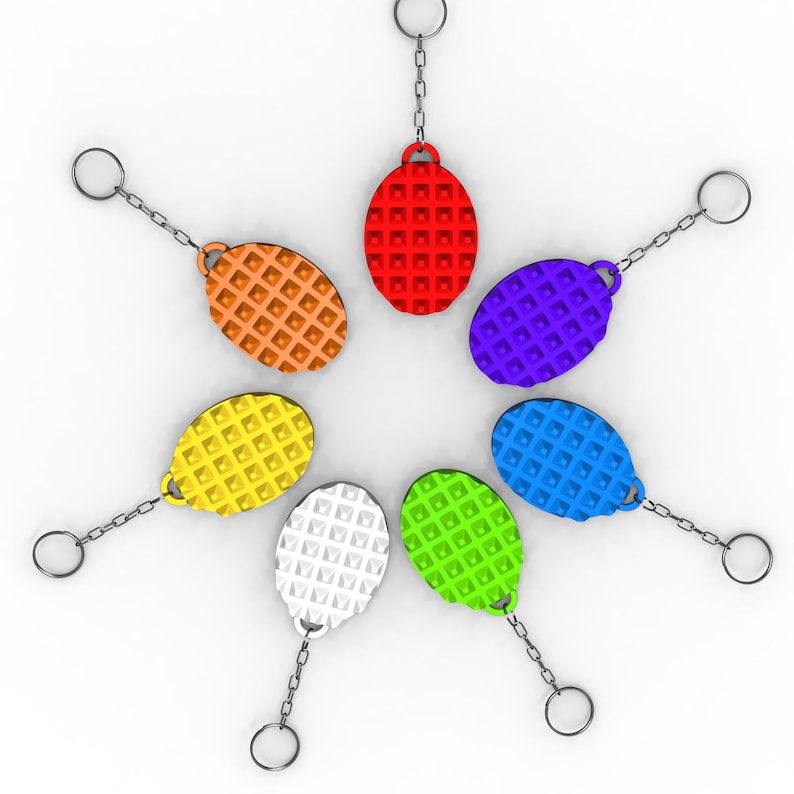May include: A collection of colorful keychains arranged in a circular pattern. Each keychain features an oval-shaped tag with a waffle-like texture, connected to a chain and a keyring. The keychains are in various colors, including red, orange, yellow, green, blue, purple, and white.