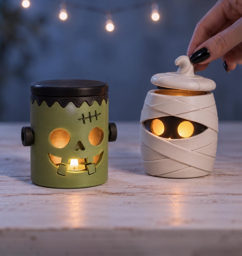 Pu&ograve; includere: Due portacandele in ceramica a forma di personaggi di Halloween. Uno &egrave; un mostro di Frankenstein verde con coperchio nero e bulloni, l'altro &egrave; una mummia color crema con coperchio rimovibile. Entrambi presentano aperture per la luce.