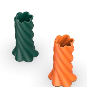 May include: Two ceramic vases with a twisted design. The vase on the left is green and the vase on the right is orange.