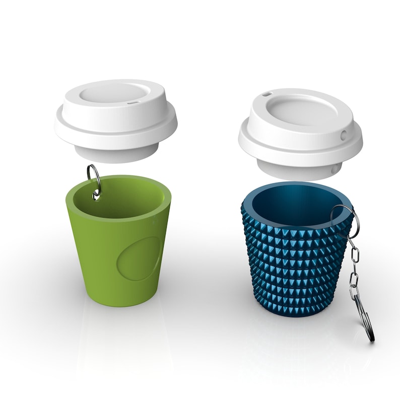 May include: Two reusable coffee cups with lids. One cup is green with a white circle and the other is blue with a textured design. Both cups have a silver ring and a silver chain.