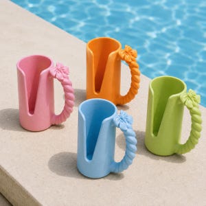 May include: Four cylindrical cup holders in pink, orange, light blue, and lime green. Each holder features a vertical cutout on the front and a twisted handle adorned with a small bow at the top, providing a secure grip for various beverage containers.
