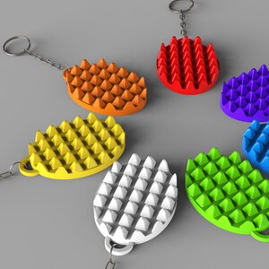 May include: A collection of colorful, textured keychains in various colors, including orange, red, yellow, white, green, blue, and purple. Each keychain has a unique, spiky design and is attached to a silver-colored chain and ring.