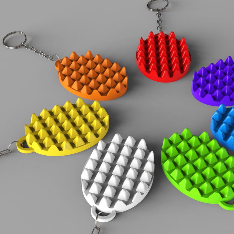 May include: A collection of colorful, textured keychains in various colors, including orange, red, yellow, white, green, blue, and purple. Each keychain has a unique, spiky design and is attached to a silver-colored chain and ring.