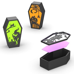 May include: Black coffin-shaped Halloween decorations with cut-out designs. One features a witch, cat, and cauldron on a green background. Another has a pumpkin, spider, and web on an orange background. The third is disassembled.