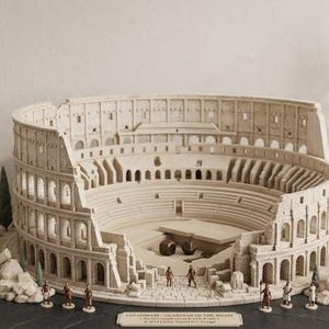 Op de afbeelding: Een gedetailleerd model van het Colosseum in Rome, Italië, in een lichtbeige kleur. Het model bevat miniatuurfiguren en staat op een donkergrijze basis. Het Colosseum-model is een decoratief item.