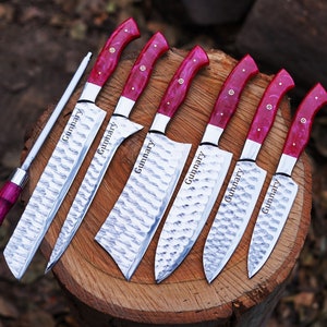 May include: Set of seven kitchen knives with red and white handles. The knives have a hammered finish and are engraved with the name "Gunnar" on the blades.