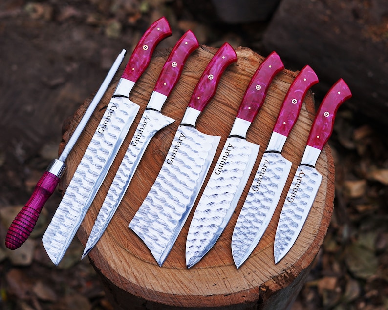 May include: Set of seven kitchen knives with red and white handles. The knives have a hammered finish and are engraved with the name "Gunnar" on the blades.