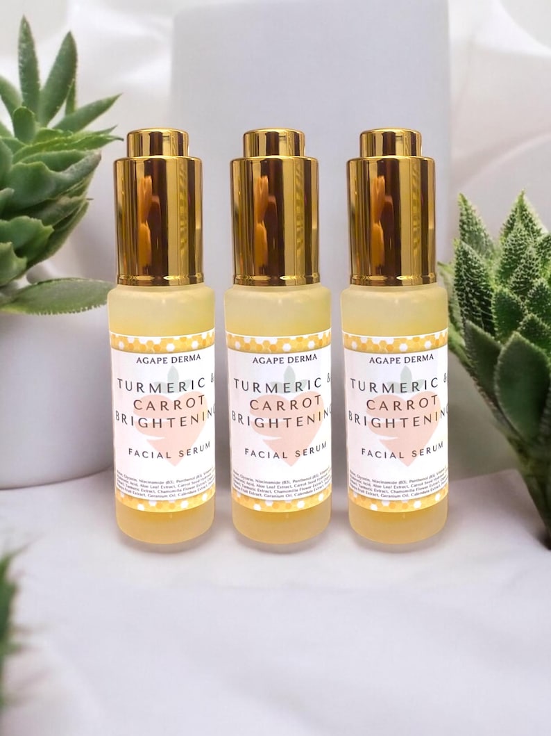 K&ouml;nnte beinhalten: Drei Flaschen Agapae Derma Gesichtsserum. Jede Flasche hat einen goldfarbenen Deckel und ein Etikett mit der Aufschrift "Turmeric & Carrot Brightening Facial Serum". Das Serum ist hellgelb.