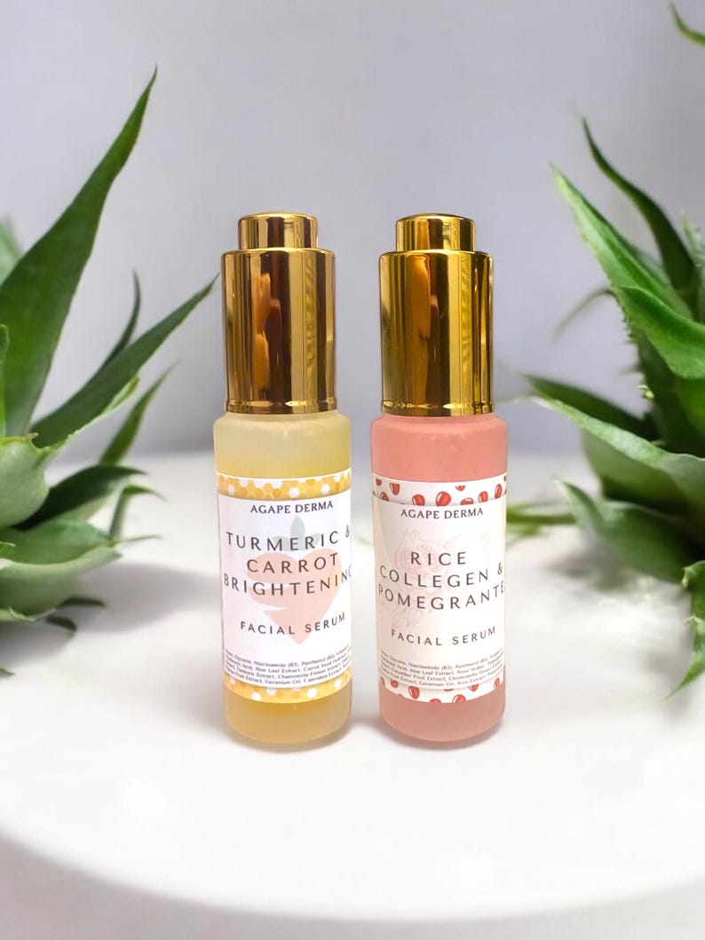 May include: Two facial serum bottles with gold-colored caps. One bottle is yellow with the text "Turmeric & Carrot Brightening Facial Serum." The other is pink with the text "Rice Collagen & Pomegranate Facial Serum."