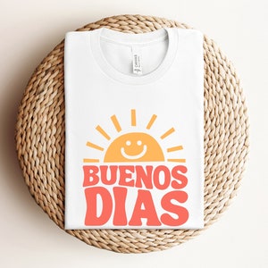 a white t - shirt with the words buenos dias printed on it