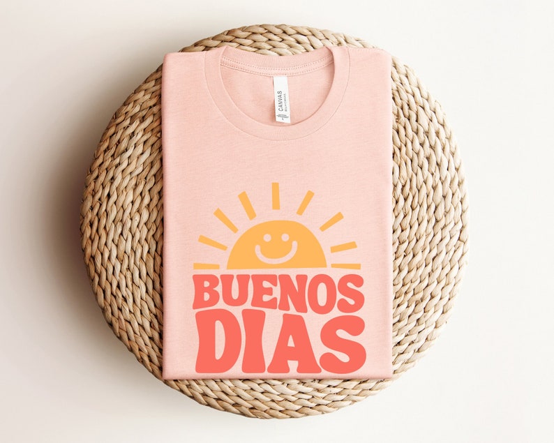 a pink t - shirt that says buenos dias on it