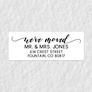 以下が含まれることがあります： 「we've moved」「MR. & MRS. JONES」「514 CREST STREET」「FOUNTAIN, CO 80817」と黒文字で書かれた白い長方形のステッカーです。