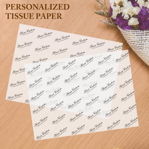May include: Two sheets of personalized tissue paper with a repeating pattern of the words "Your Custom" and "TEXT/LOGO/PHOTO" in a delicate script. The text is in black on a light beige background. The words "PERSONALIZED TISSUE PAPER" are at the top.