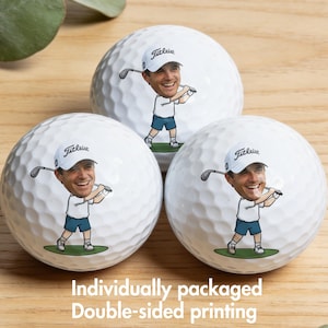May include: Three white golf balls with a personalized cartoon image of a golfer. Each ball features a smiling golfer wearing a white hat with "Titleist" printed on it, a white shirt, and blue shorts. The text "Individually packaged Double-sided printing" is at the bottom.