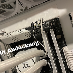 Könnte beinhalten: Nahaufnahme einer Computer-Hauptplatine mit weißen Kabeln und einem weißen Kühlkörper. Die Hauptplatine hat einen schwarzen Hintergrund und der Text "Mit Abdeckung" ist auf dem Bild zu sehen.