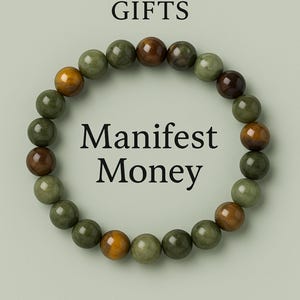 May include: A beaded bracelet with green, brown, and yellow beads. The text "Manifest Money" is centered within the bracelet's circle. The top of the image reads "Lovella GIFTS".