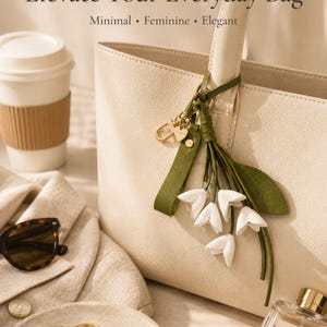 White floral bag charm with leather flowers and gold hardware, elegant purse charm accessory for women, luxury handbag charm with tassel, aesthetic white keychain for tote bag, trendy flower purse accessory, feminine handbag decoration, modern leather floral keychain, gift for her, cute white purse charm, boutique style bag accessory, minimal elegant keychain for handbags, stylish floral charm for purse, luxury fashion bag accessory