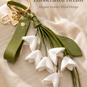White floral bag charm with leather flowers and gold hardware, elegant purse charm accessory for women, luxury handbag charm with tassel, aesthetic white keychain for tote bag, trendy flower purse accessory, feminine handbag decoration, modern leather floral keychain, gift for her, cute white purse charm, boutique style bag accessory, minimal elegant keychain for handbags, stylish floral charm for purse, luxury fashion bag accessory