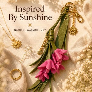 Handmade sunflower bag charm featuring soft pink leather flowers, olive green leather tassel, premium gold sunflower charm and luxury gold hardware. Botanical handbag accessory designed for tote bags, leather handbags, shoulder bags, crossbody bags, straw bags, beach bags and backpacks. Cottagecore purse charm inspired by nature and garden style. Floral bag jewelry, handmade leather keychain, lightweight purse decoration, gift for women, Mother's Day gift, birthday gift, bridesmaid gift.