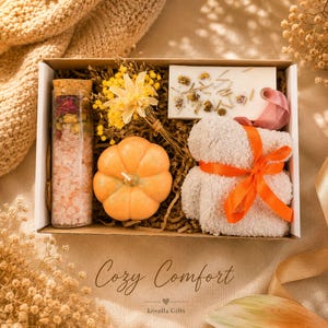 Fall gift box for women, handmade pumpkin soy candle, ceramic mug, artisan soap, decorative glass match bottle, plush teddy bear and cozy autumn socks beautifully arranged in boutique gift packaging. Cozy gift basket and autumn care package perfect as a blanket gift, hygge self care gift, comfort gift, thinking of you gift, appreciation gift, housewarming gift, Thanksgiving hostess gift, birthday gift, get well soon gift and seasonal gift for mom, grandma, sister, friend or coworker.