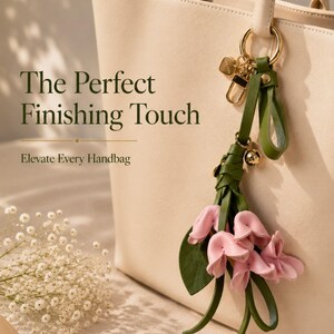 Luxury botanical leather bag charm featuring blush pink leather flowers, olive green leather leaves, decorative tassel, wrist loop, premium gold hardware, and elegant handbag accessory. Handmade floral purse charm designed for luxury handbags, designer inspired totes, shoulder bags, crossbody purses, woven beach bags, and everyday handbags. Arrives beautifully packaged in a signature gift box, making a ready to gift birthday gift, Mother's Day gift, bridesmaid gift, Christmas gift for women.