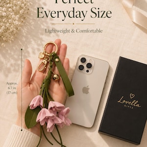 Luxury botanical leather bag charm featuring blush pink leather flowers, olive green leather leaves, decorative tassel, wrist loop, premium gold hardware, and elegant handbag accessory. Handmade floral purse charm designed for luxury handbags, designer inspired totes, shoulder bags, crossbody purses, woven beach bags, and everyday handbags. Arrives beautifully packaged in a signature gift box, making a ready to gift birthday gift, Mother's Day gift, bridesmaid gift, Christmas gift for women.