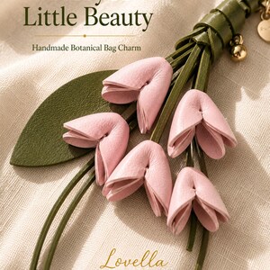Luxury botanical leather bag charm featuring blush pink leather flowers, olive green leather leaves, decorative tassel, wrist loop, premium gold hardware, and elegant handbag accessory. Handmade floral purse charm designed for luxury handbags, designer inspired totes, shoulder bags, crossbody purses, woven beach bags, and everyday handbags. Arrives beautifully packaged in a signature gift box, making a ready to gift birthday gift, Mother's Day gift, bridesmaid gift, Christmas gift for women.