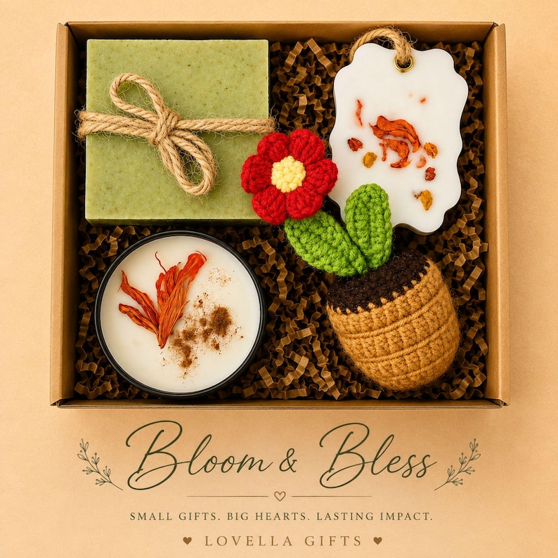 May include: A gift box containing a square green soap tied with twine, a white wax tablet with dried petals, a round candle with orange botanicals, and a crocheted flower in a brown pot. Text reads Bloom & Bless, Small Gifts. Big Hearts. Lasting Impact. Lovella Gifts.