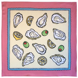 May include: A pink and blue patterned square scarf with a yellow background featuring a repeating pattern of oysters, lemons, and olives.