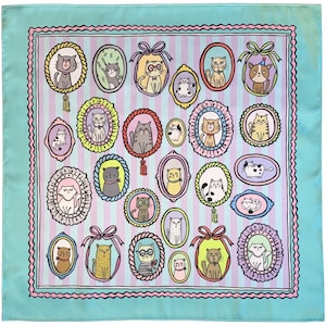 May include: A turquoise blue square fabric with a pink and white striped pattern. The fabric is decorated with a repeating pattern of oval frames with illustrations of cats in various poses. The frames are decorated with pink, yellow, and blue accents.