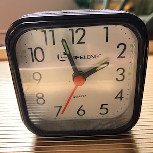 Vintage Mini Quartz Lifelong Alarm Clock, Black Plastic Case, White Face + Black Numbers, Night Glow Hands, Battery-Operated, 1980s China
