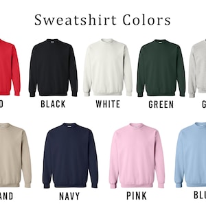May include: A selection of ten crewneck sweatshirts in various colours, including red, black, white, green, grey, sand, navy, pink, blue, and light blue.  The sweatshirts are all the same style and have a relaxed fit.