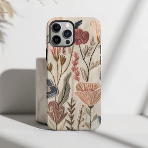 Embrace the beauty of nature with our Retro Floral Faux Embroidery Phone Case.  Designed with nature in mind, this bohemian flowers phone case features a flat surface print of flowers on a vintage look background