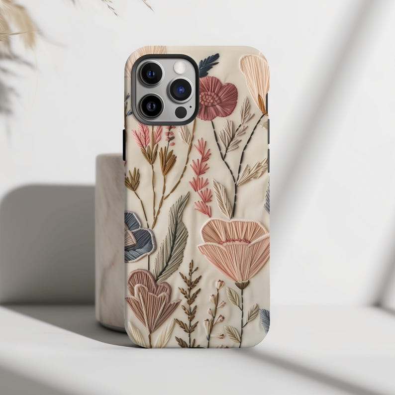 Embrace the beauty of nature with our Retro Floral Faux Embroidery Phone Case.  Designed with nature in mind, this bohemian flowers phone case features a flat surface print of flowers on a vintage look background