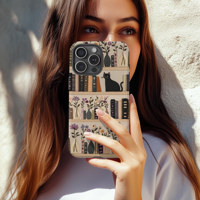 Embrace books and nature with our Bookish Boho Floral Phone Case.  Designed with book lovers in mind, this faux embroidery cat on bookshelf phone case features a flat surface print of shelved books, a cat and flowers on a vintage look background
