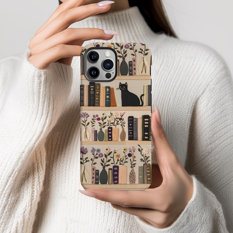 Embrace books and nature with our Bookish Boho Floral Phone Case.  Designed with book lovers in mind, this faux embroidery cat on bookshelf phone case features a flat surface print of shelved books, a cat and flowers on a vintage look background