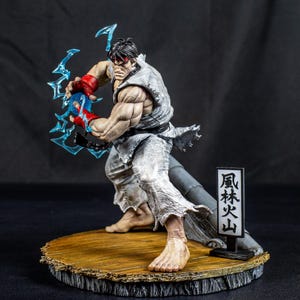 Könnte beinhalten: Eine detaillierte Actionfigur eines muskulösen Kämpfers mit schwarzen Haaren und rotem Stirnband, bekleidet mit einem zerrissenen weißen Gi und roten Handschuhen. Die Figur steht in einer dynamischen Pose, erzeugt einen blauen Energieeffekt und befindet sich auf einem Holzsockel mit einem Schild, das die japanischen Schriftzeichen 風林火山 zeigt.
