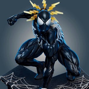 May include: A black and white Spider-Man figurine in a crouching pose, featuring a textured black suit with a white spider emblem on the chest and white eye lenses. The figure has translucent yellow lightning bolt effects radiating from the head.