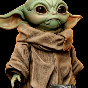 Pu&ograve; includere: Una statuetta dettagliata di Grogu, noto anche come Baby Yoda, da The Mandalorian. La figura ha grandi occhi marroni, pelle verde e grandi orecchie. Grogu indossa una veste color cachi. La base della figura riporta la scritta "The Mandalorian Grogu".