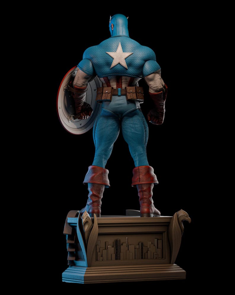 May include: A blue Captain America statue, viewed from the back, with a white star on the back of the costume. The statue is holding a shield and wearing brown boots. The statue is standing on a brown base with a city skyline.