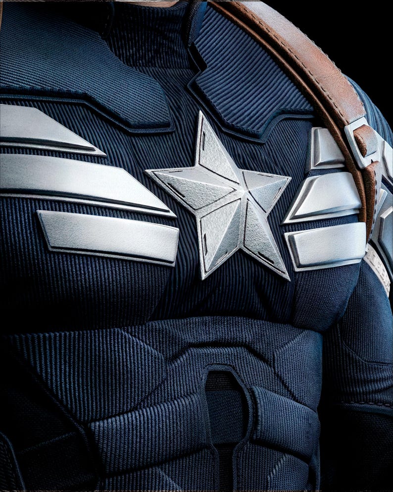 May include: Close-up of a navy blue costume with silver accents and a large silver star emblem. The costume features a textured design and a brown leather strap. The overall theme is superhero attire.