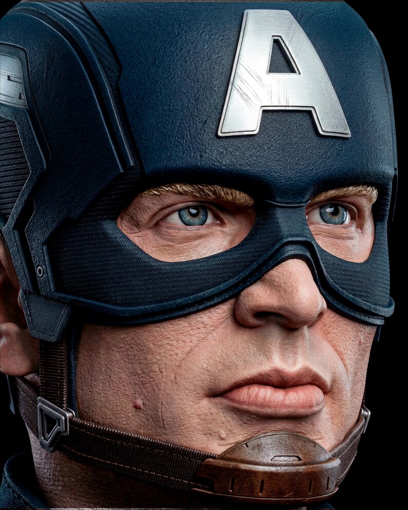 May include: Close-up of a Captain America helmet. The helmet is primarily navy blue with a silver "A" emblem on the forehead. The mask is black, and the chin strap is brown.