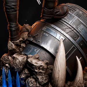 May include: A detailed sculpture featuring a figure's boots atop a metallic, cylindrical structure. The sculpture includes rocky terrain and three blue, glowing, icicle-shaped elements. The boots are brown, and the structure is metallic.