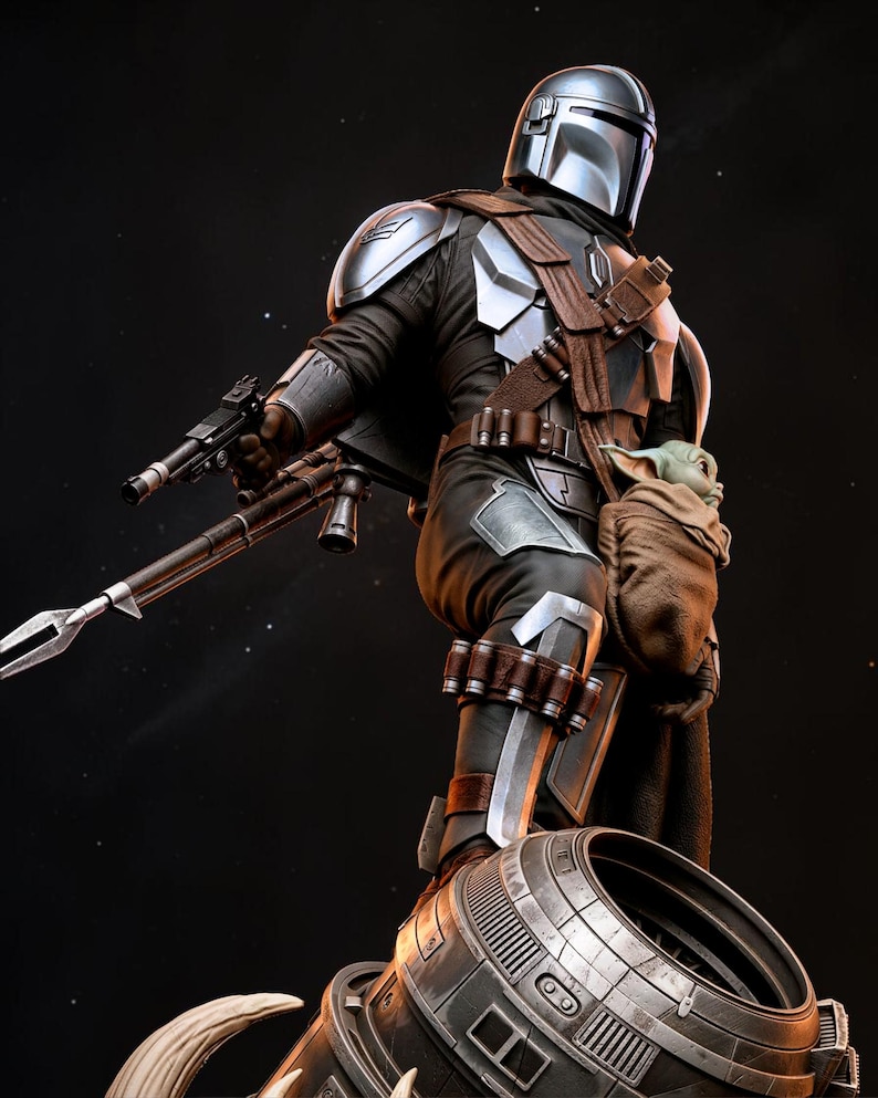 May include: A detailed figurine of The Mandalorian in a dynamic pose, clad in silver and black armor, holding a blaster and a rifle. A small figure of Grogu is in a pouch. The figure is set against a dark, starry background.
